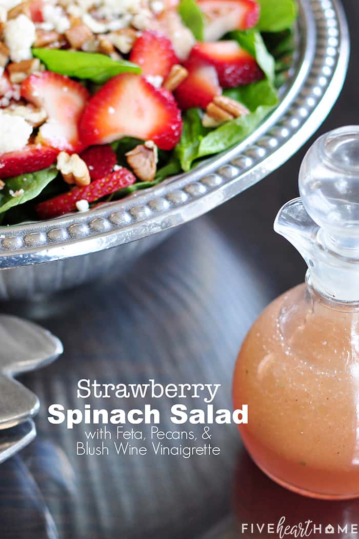 Strawberry Spinach Salad in a pewter salad bowl with Homemade Blush Wine Vinaigrette on the side and text overlay