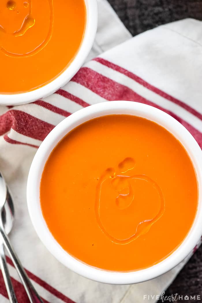 Aerial view of two bowls of Gazpacho drizzled with olive oil.