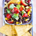 Black Bean and Corn Salad with Tomatoes + Cilantro ~ an easy, zesty, addictive recipe with a garlicky lime vinaigrette that's delicious as a side salad or dipped up with chips! | FiveHeartHome.com #blackbeancornsalad #summersalads #blackbeansalad #cornsalad #tomatosalad