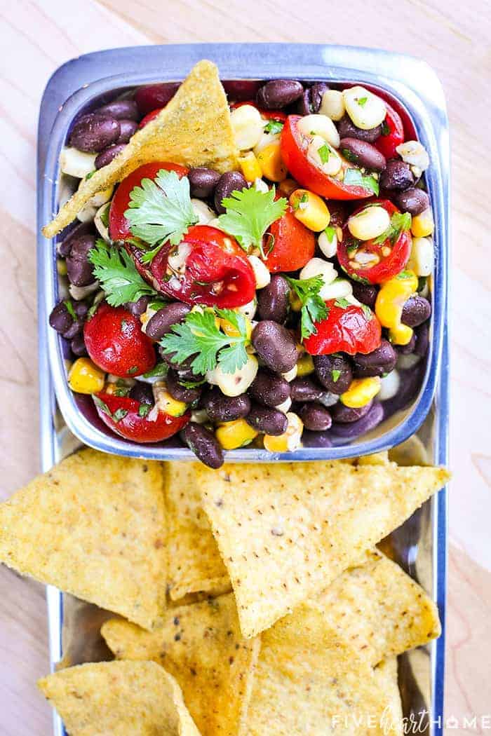Black Bean and Corn Salad with Tomatoes + Cilantro ~ an easy, zesty, addictive recipe with a garlicky lime vinaigrette that's delicious as a side salad or dipped up with chips! | FiveHeartHome.com #blackbeancornsalad #summersalads #blackbeansalad #cornsalad #tomatosalad