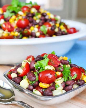 Black Bean and Corn Salad with Tomatoes + Cilantro ~ an easy, zesty, addictive recipe with a garlicky lime vinaigrette that's delicious as a side salad or dipped up with chips! | FiveHeartHome.com #blackbeancornsalad #summersalads #blackbeansalad #cornsalad #tomatosalad