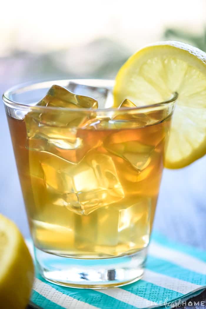 Arnold Palmer Spiked in a glass garnished with a slice of lemon.