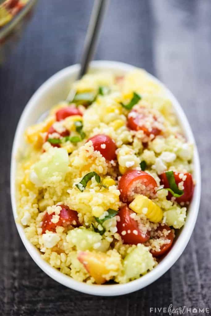 Summer Couscous Salad ~ a flavorful side dish featuring fluffy couscous studded with fresh corn, juicy tomatoes, crisp cucumbers, sweet peaches, chopped basil, and creamy feta in a honey lime dressing! | FiveHeartHome.com #couscous #couscoussalad #couscousrecipe #summersalad