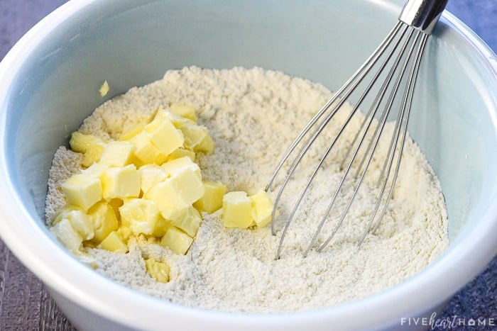 Adding butter to dry ingredients for simple muffin recipe.