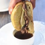 Slow Cooker French Dip ~ this crock pot recipe features succulent beef slow cooked in a flavorful broth, served on toasty rolls with melted cheese and extra au jus for dipping! | FiveHeartHome.com