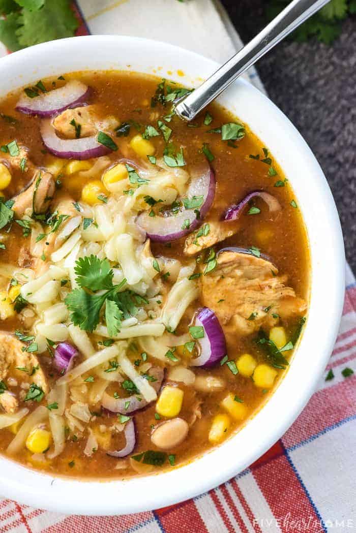 Aerial view of BBQ Chicken Soup recipe in bowl with spoon.