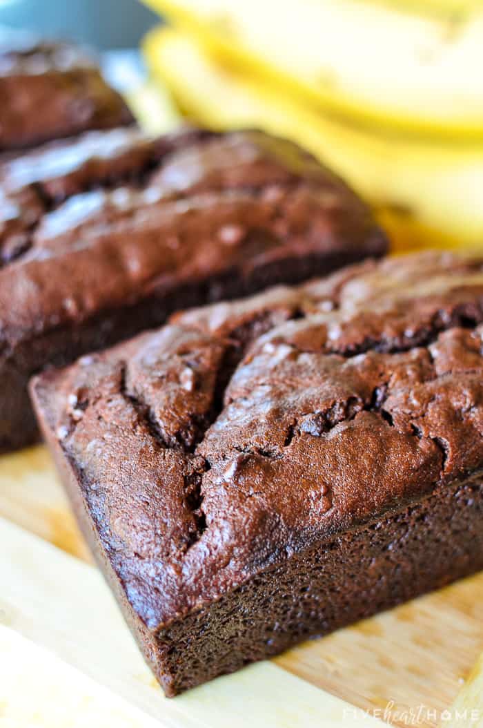 3 loaves of Chocolate Banana Bread with bananas in background