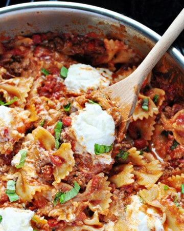 Aerial view of Skillet Lasagna in pan with wooden spoon.