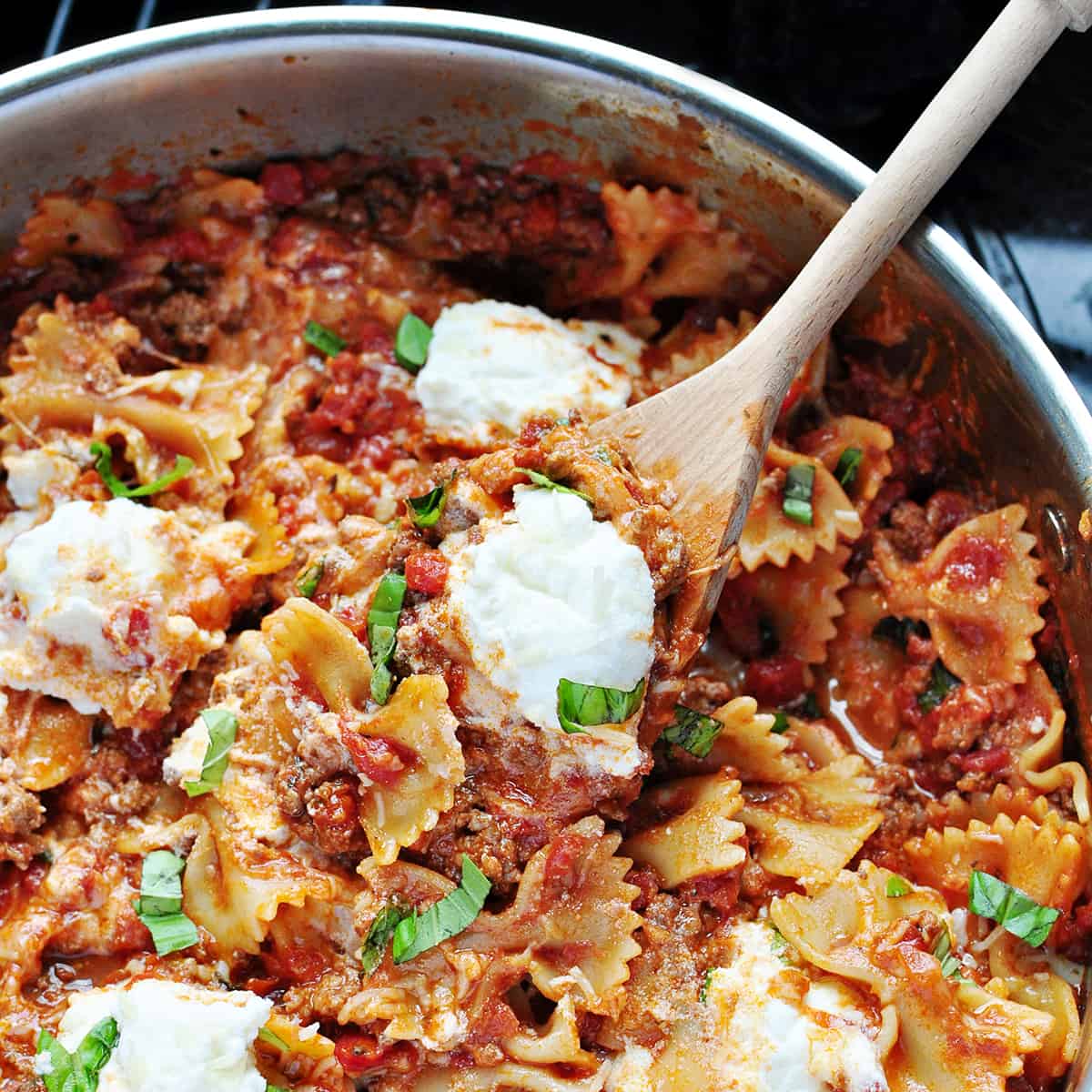 Aerial view of Skillet Lasagna in pan with wooden spoon.