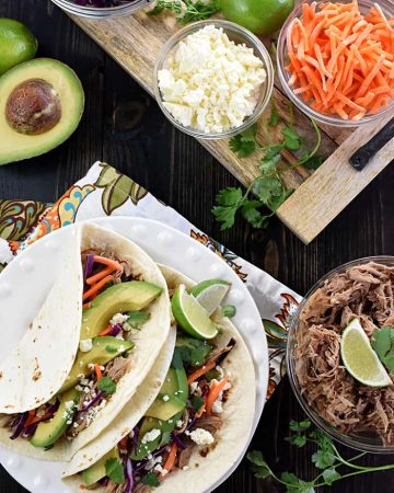Aerial shot of Slow Cooker Pork Tacos plus garnishes.