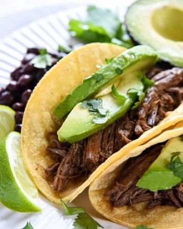 Slow Cooker Barbacoa ~ a delicious addition to tacos, burritos, rice bowls, salads, and more...and this easy, succulent, crockpot version is bursting with chipotles, garlic, cilantro, & Mexican spices! | FiveHeartHome.com