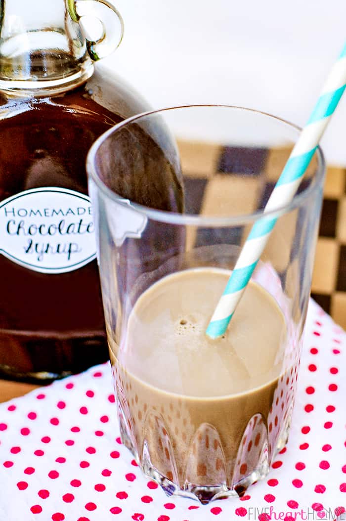 Easy Homemade Chocolate Syrup ~ this chocolate syrup recipe is made with five simple ingredients in about five minutes. It's a scrumptious topping for ice cream and makes perfect chocolate milk. And not only is it economical, but it also doesn't contain the additives and preservatives found in many store-bought brands! | FiveHeartHome.com Chocolate syrup recipe stirred into glass for chocolate milk.