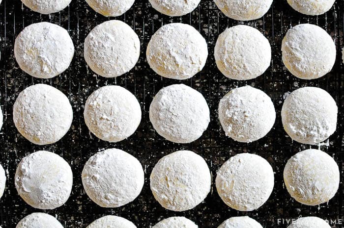 Lemon Cooler Cookies ~ soft, tender cookies bursting with fresh lemon and real butter, then coated in lemony powdered sugar! | FiveHeartHome.com Aerial view, coated with powdered sugar and cooling on rack.