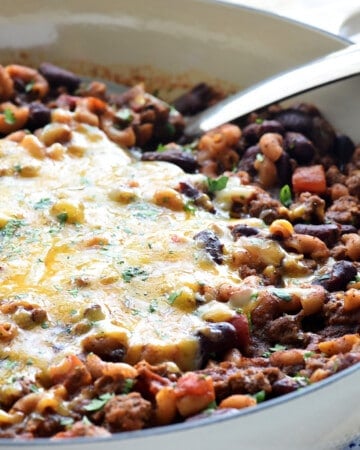 Chili Mac recipe in skillet topped with melted cheese.