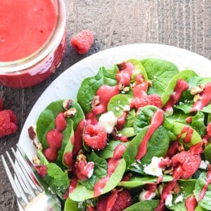 Aerial view of Raspberry Vinaigrette in jar and drizzled over salad.