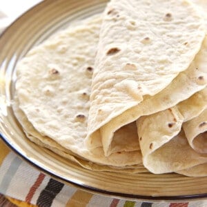 Flour Tortillas piled on plate.