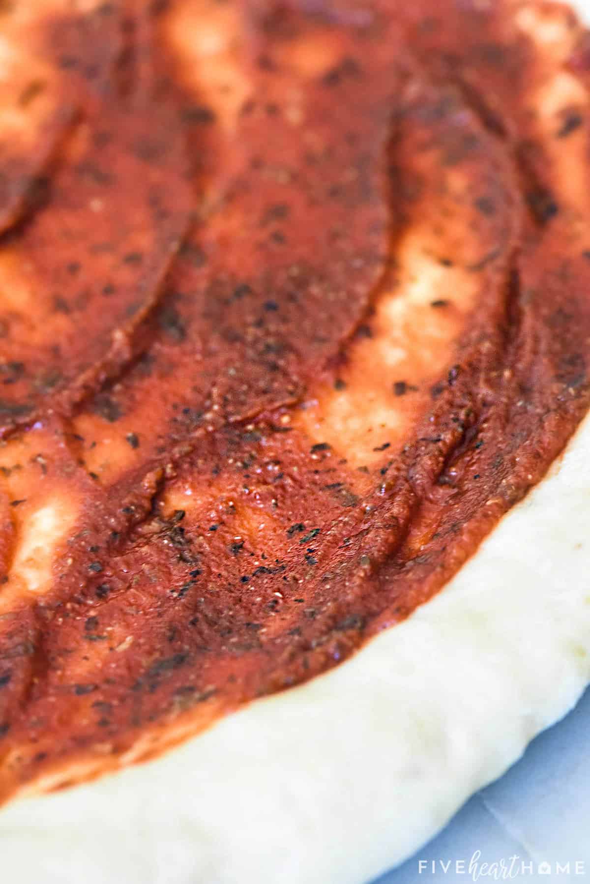 Close-up of Best Pizza Sauce spread on pizza crust.