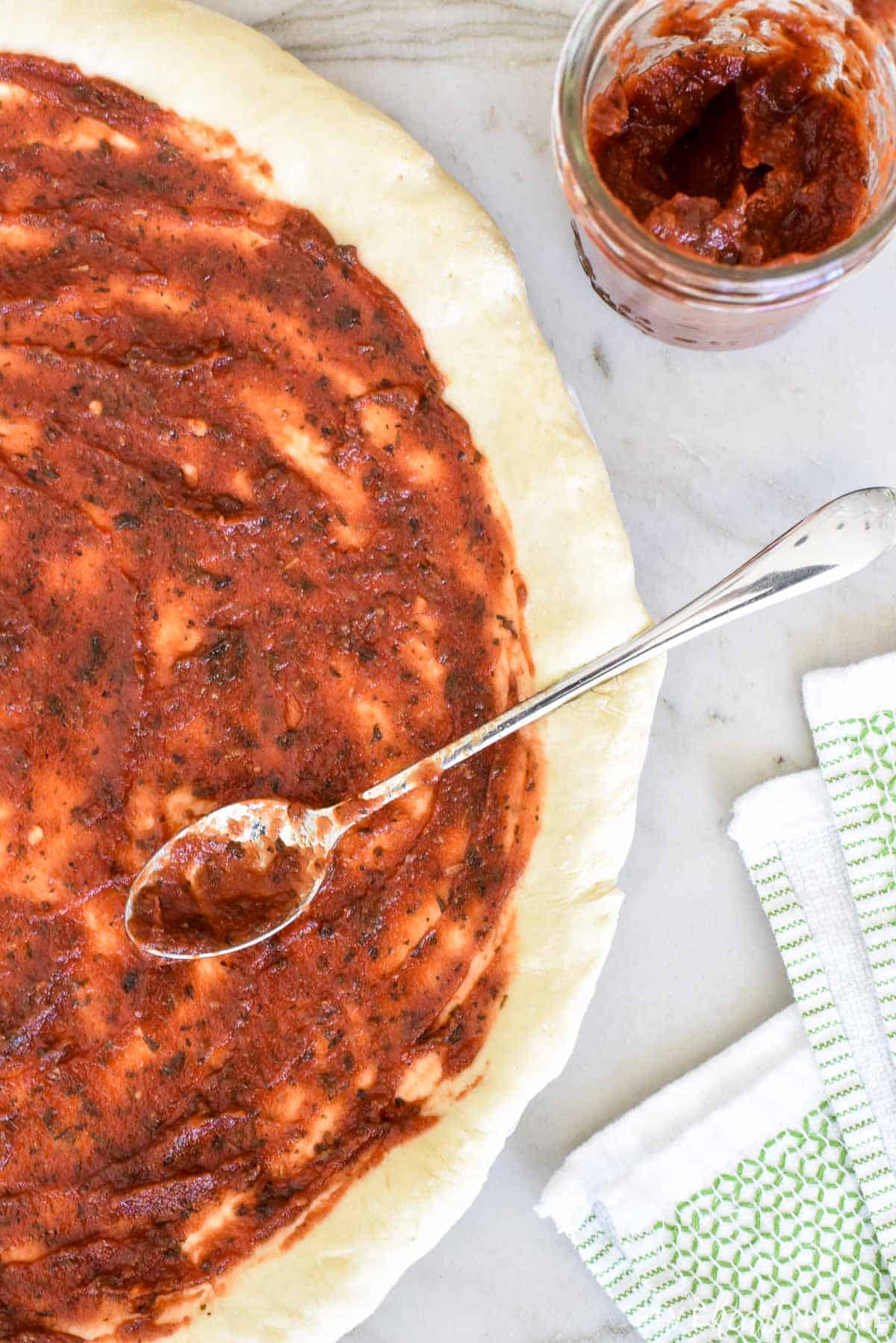 Pizza Sauce Recipe being spread on a pizza.