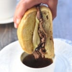 Dipping a Slow Cooker French Dip sandwich into au jus.