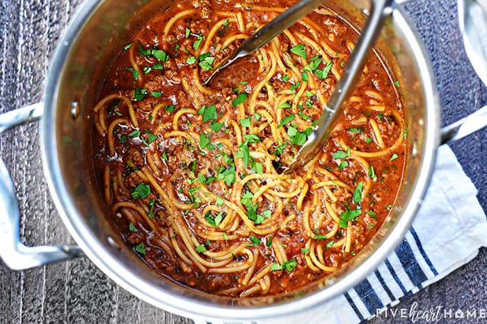 Aerial view of One Pot Spaghetti in pot with tongs.