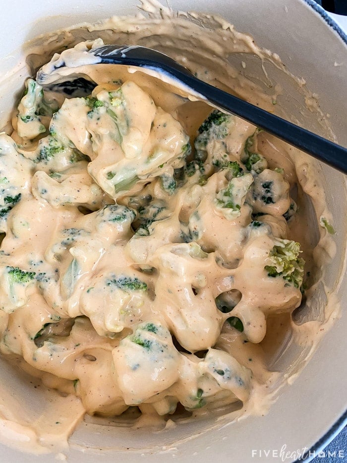 Broccoli combined with cheese sauce in pot.