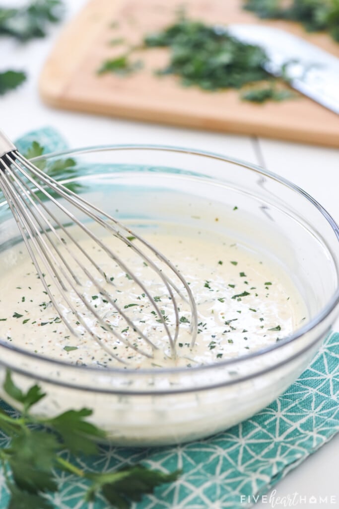 Homemade Ranch Dressing recipe with chopped parsley in background.