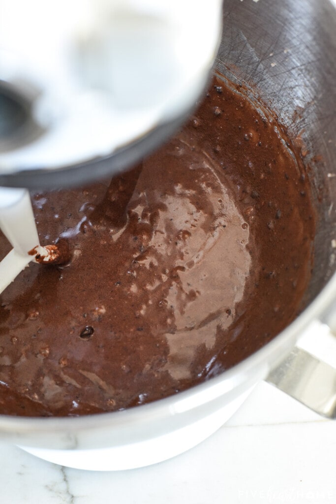 Cocoa powder blended into flourless peanut butter brownie recipe in mixer.