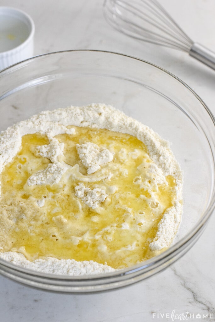 Butter and egg whisked into masa mixture in glass bowl.