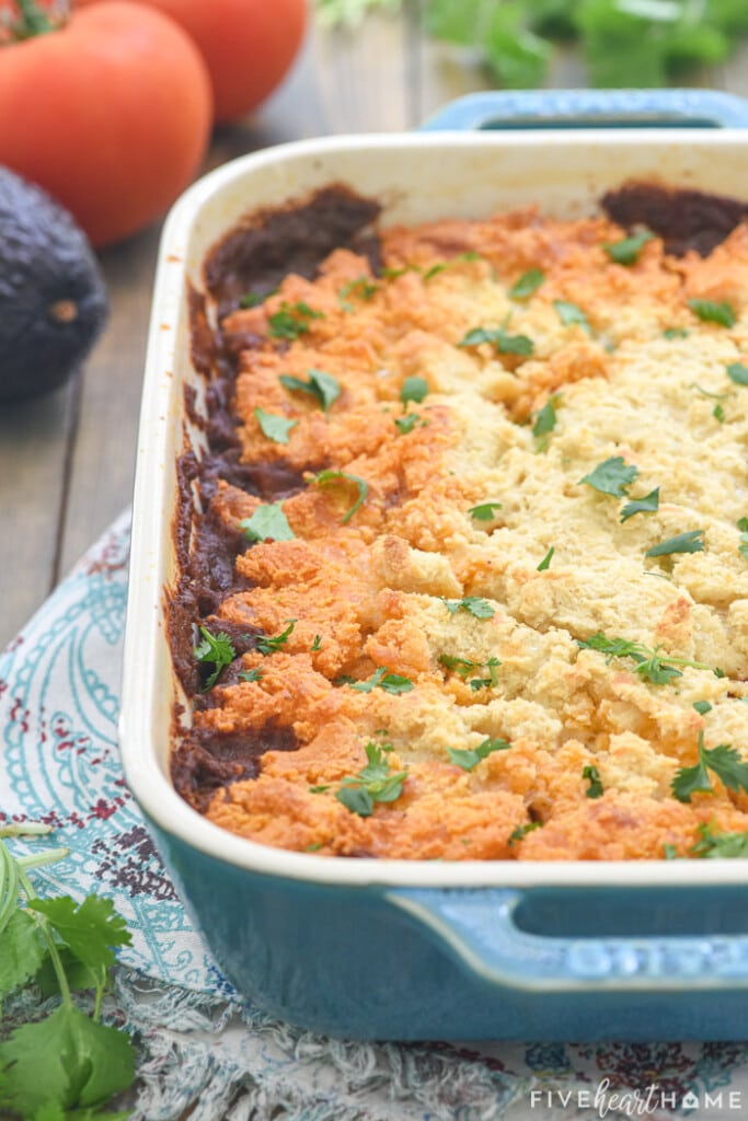 Tamale Pie garnished with cilantro in blue baking dish on table.