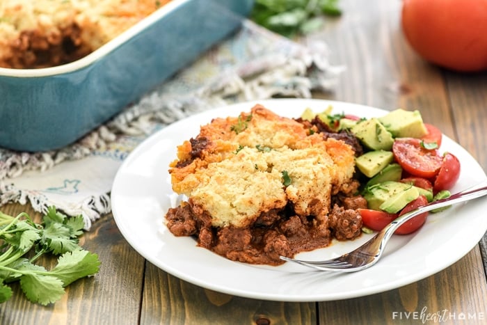 Serving of Tamale Pie on a plate with fork and salad.