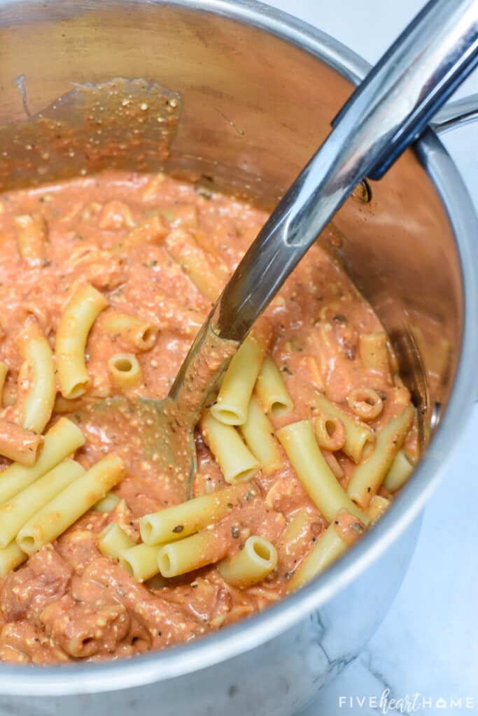Combining ziti and sauce in large pot.