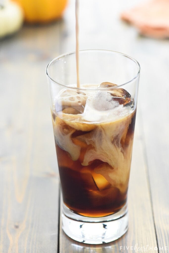 Pumpkin Cream Cold Brew being made as cream is poured into iced coffee.