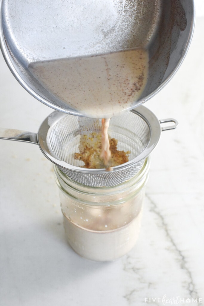 Straining the foam mixture through a sieve into a jar.