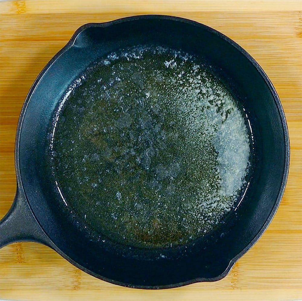 Cast iron skillet with melted butter.