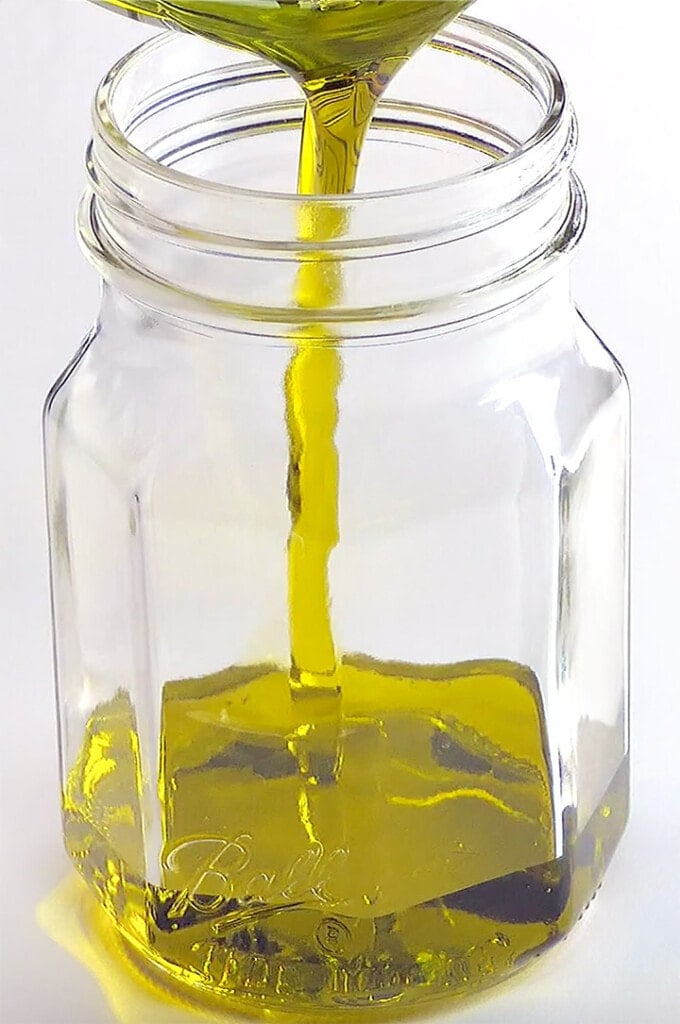 Pouring olive oil in jar.