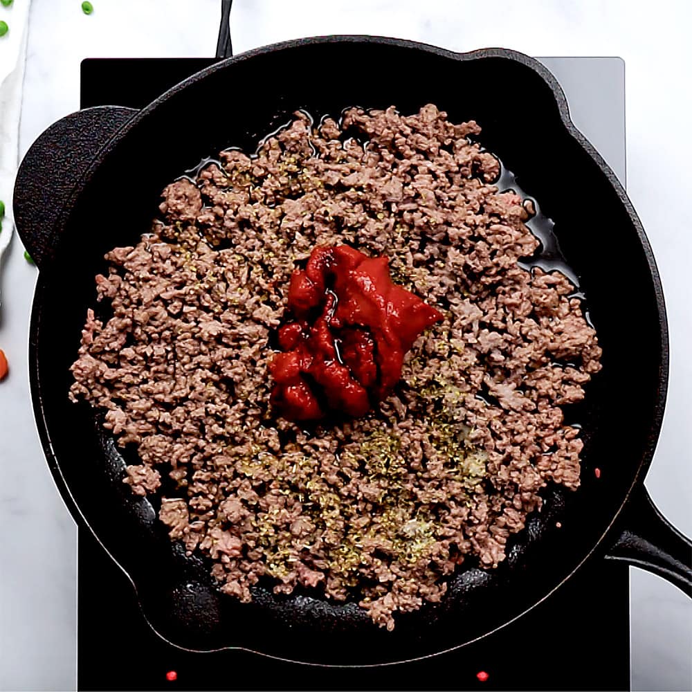 Tomato paste, Worcestershire, and oregano added to ground beef.