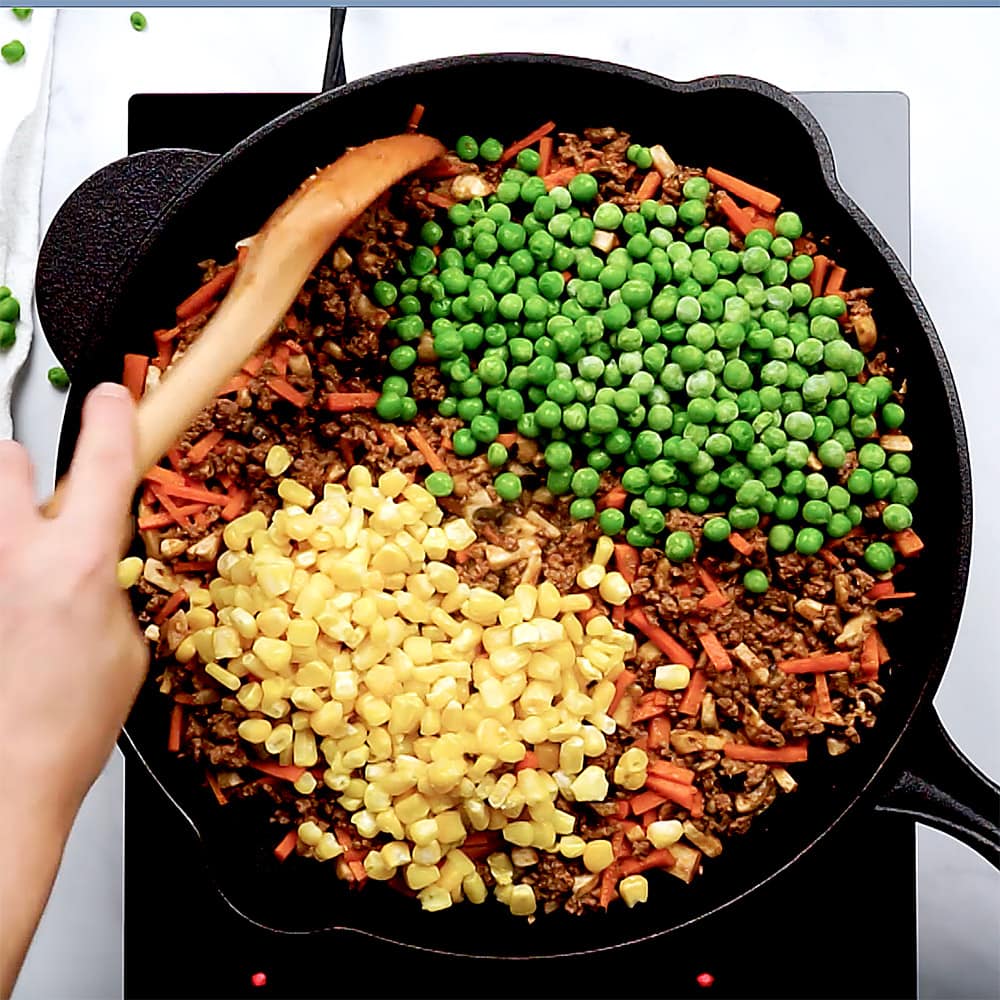 Stirring in peas and corn.