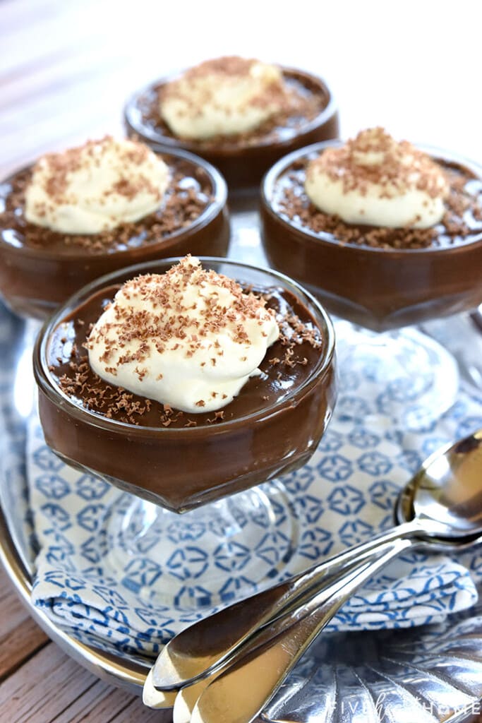 Four glass bowls of Homemade Chocolate Pudding on tray.