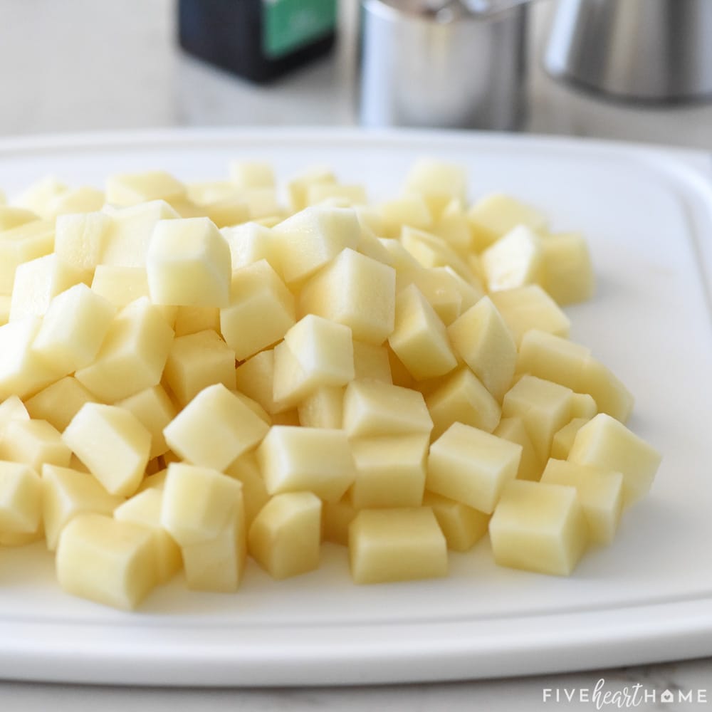 Peeled, cubed potatoes on cutting board.