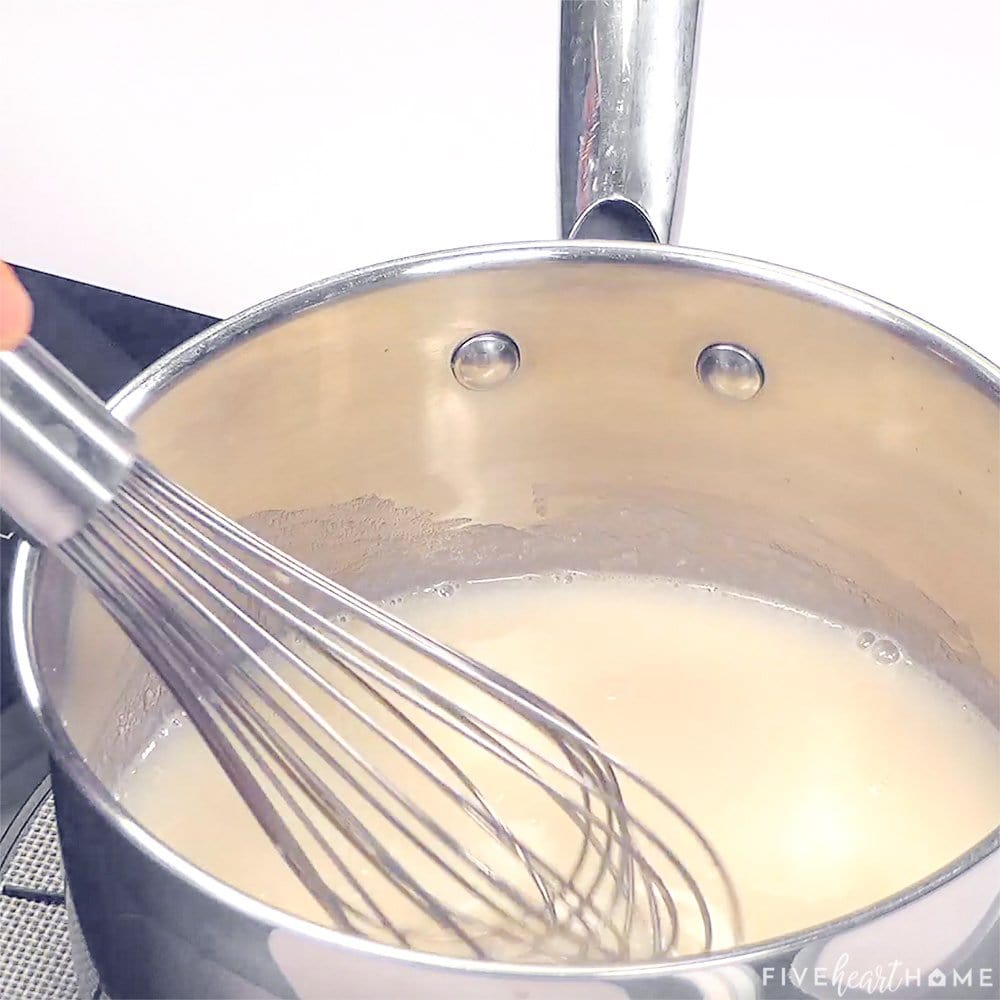 Whisking homemade sauce in pot.