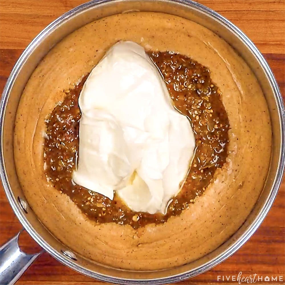 Adding green salsa and sour cream to from-scratch sauce.