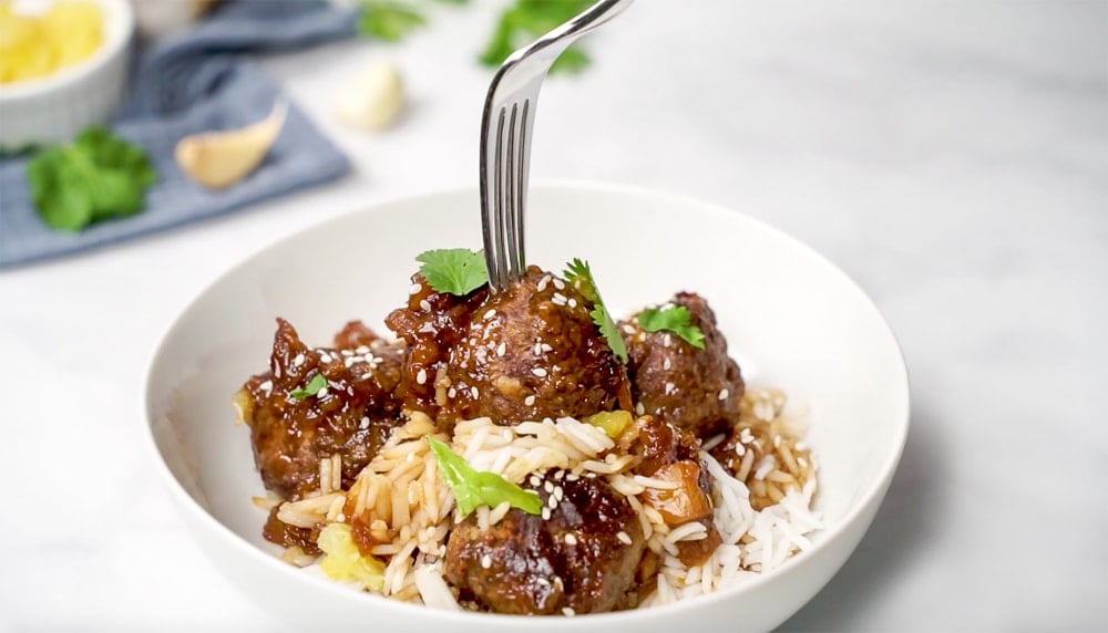 Hawaiian Meatballs in bowl with fork.