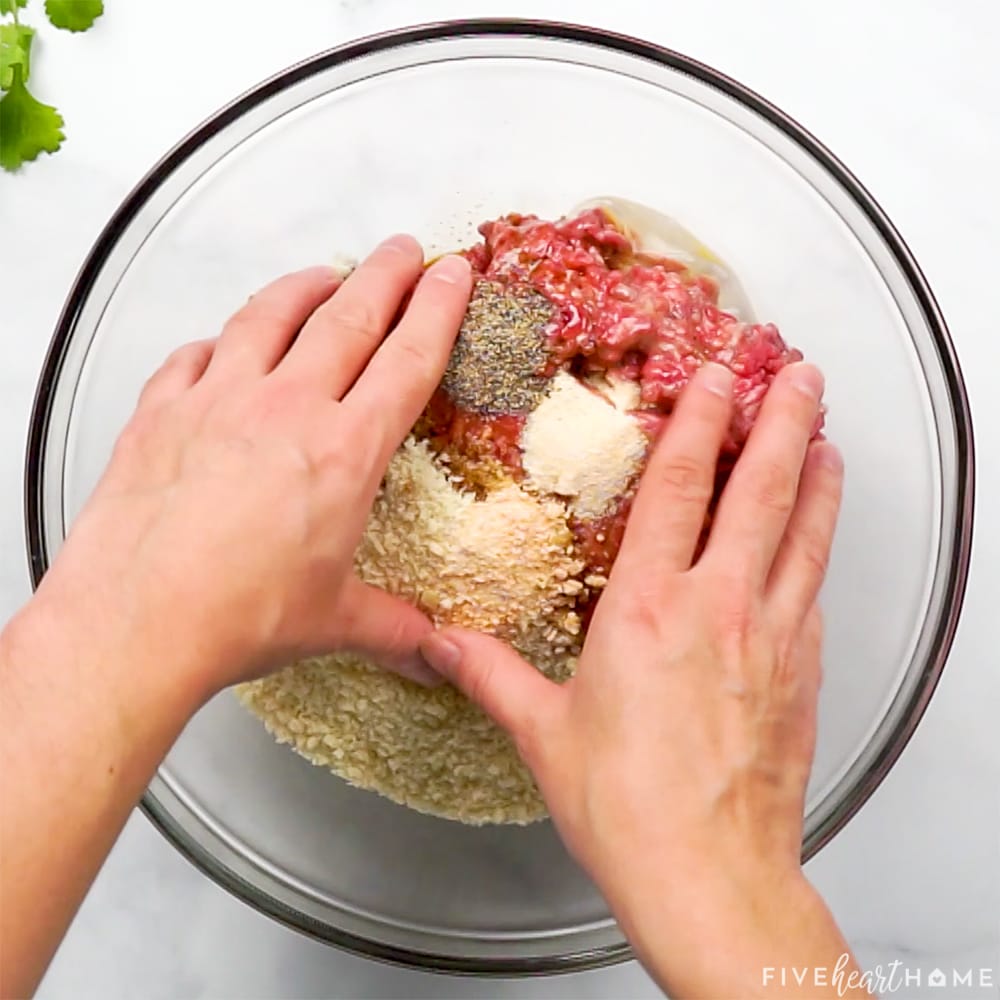 Mixing ground beef with other ingredients.