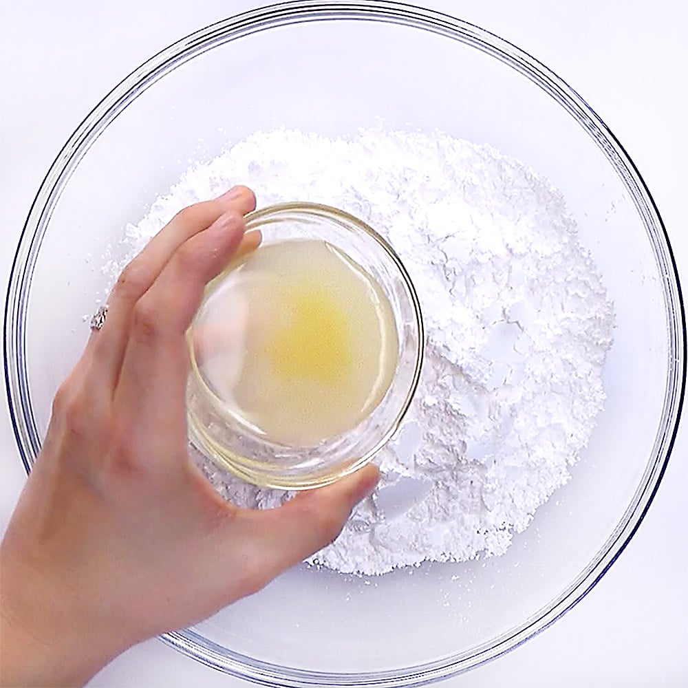 Making lemon glaze by combining powdered sugar and lemon juice.