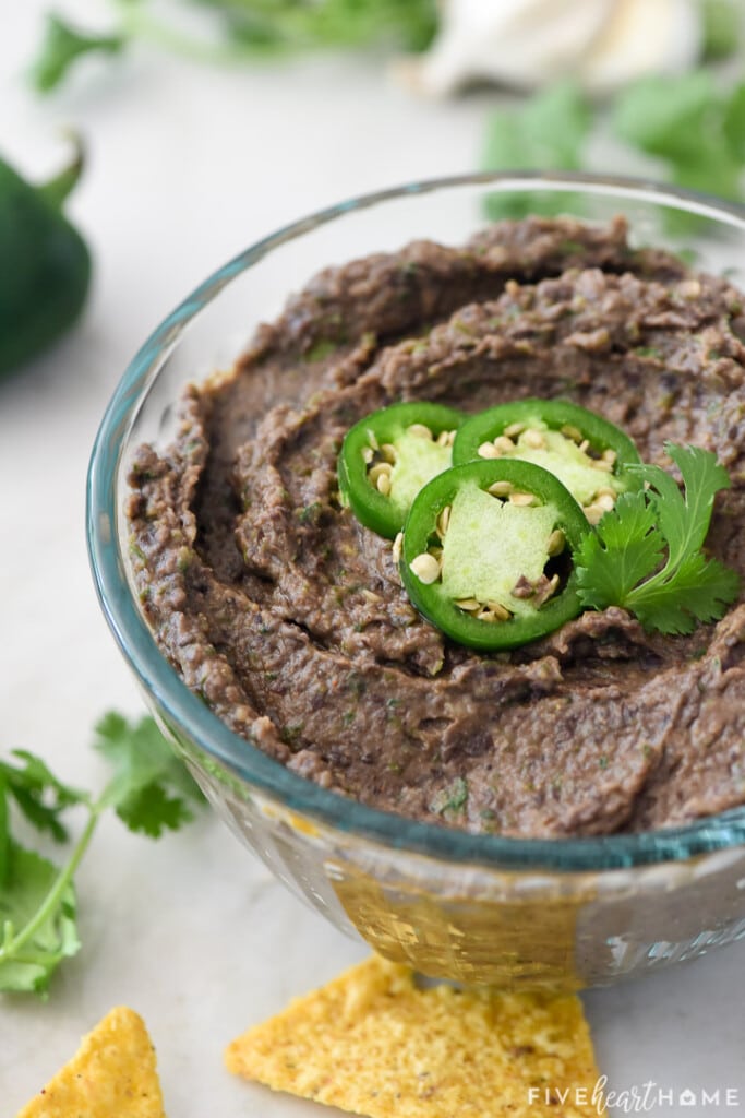 Bowl of Black Bean Dip garnished with jalapeño slices.