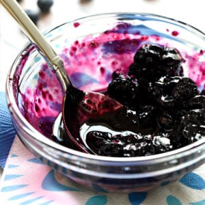 Blueberry Compote in glass bowl with spoon.