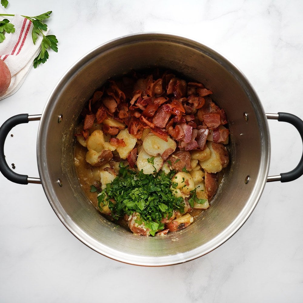 Adding bacon and parsley to pot.