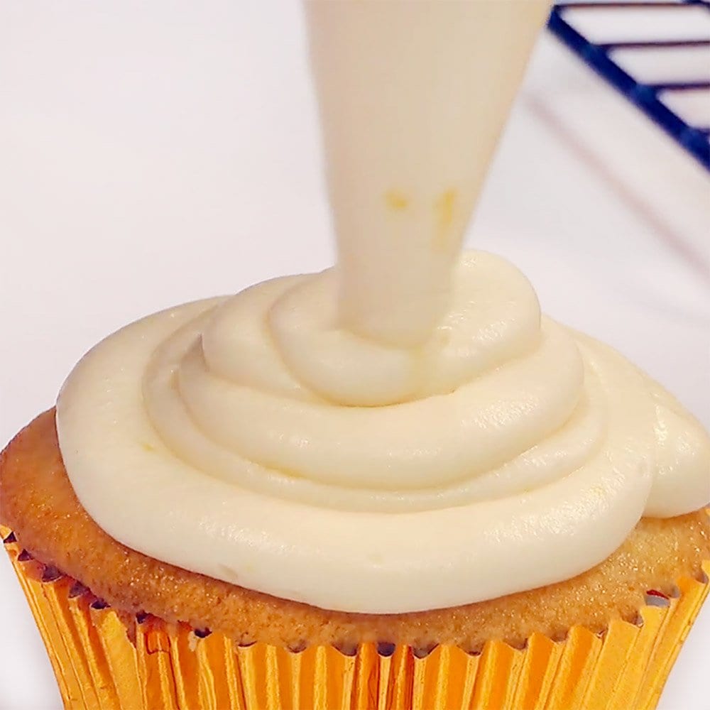 Piping Lemon Cream Cheese Frosting on Lemon Cupcake.