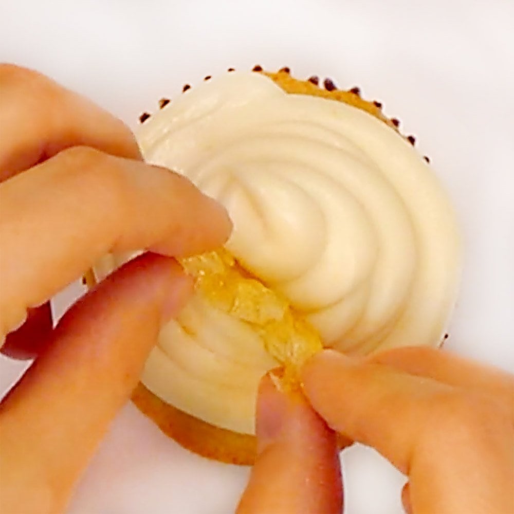 Garnishing top of frosting with candied lemon.