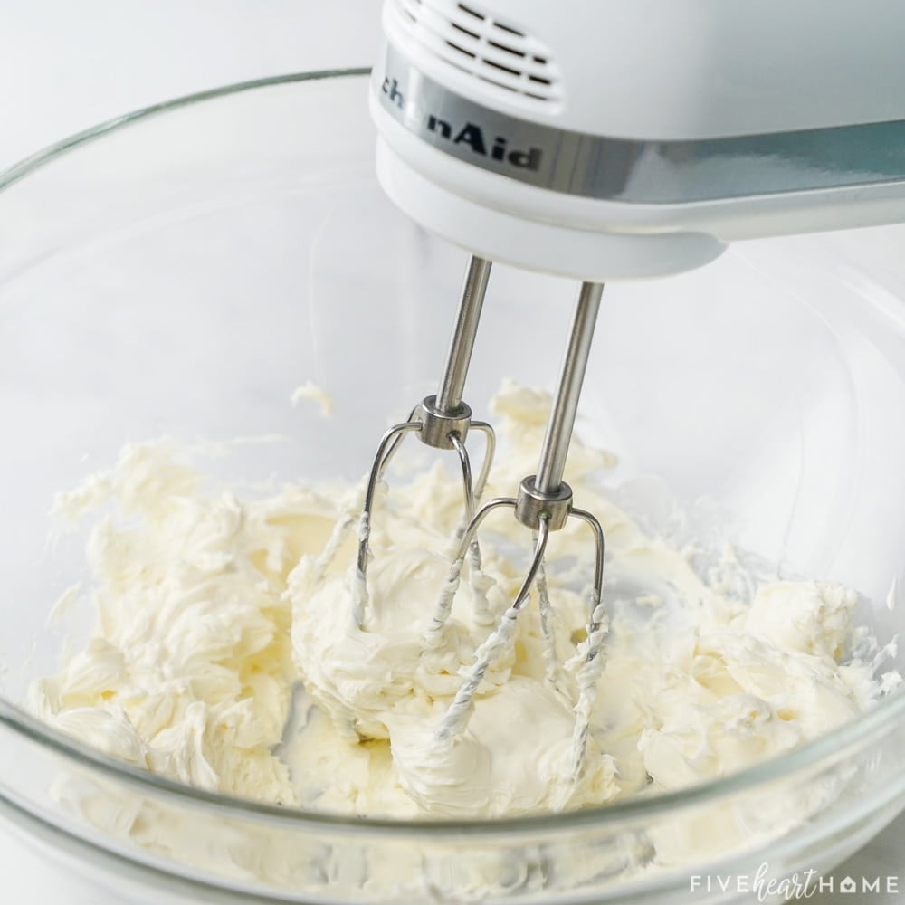 Beating cream cheese with electric mixer.